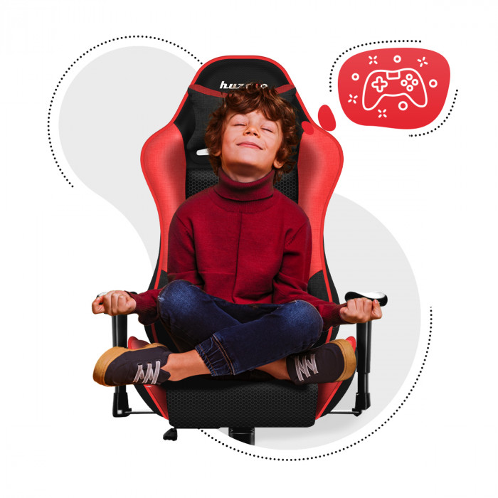 A boy sitting on a Huzaro Ranger 6.0 Red gaming chair holding an open book in his hands